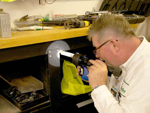 Safer Home Services technician checking table with light